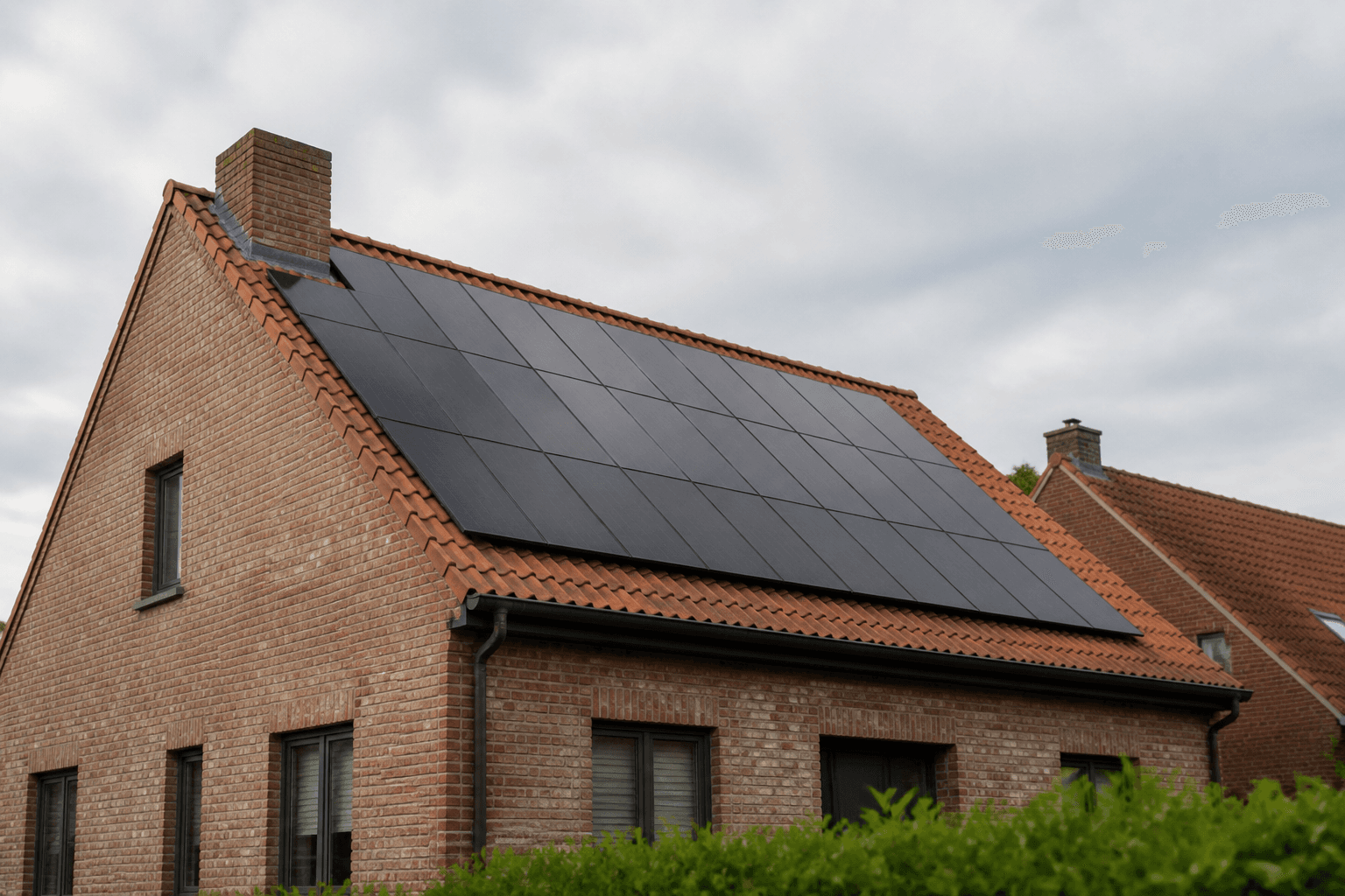 Zwarte zonnepanelen op het dak van een Belgische bakstenen woning